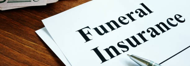 Funeral insurance document on wooden table with pen and cash, highlighting the importance of planning for funeral expenses.